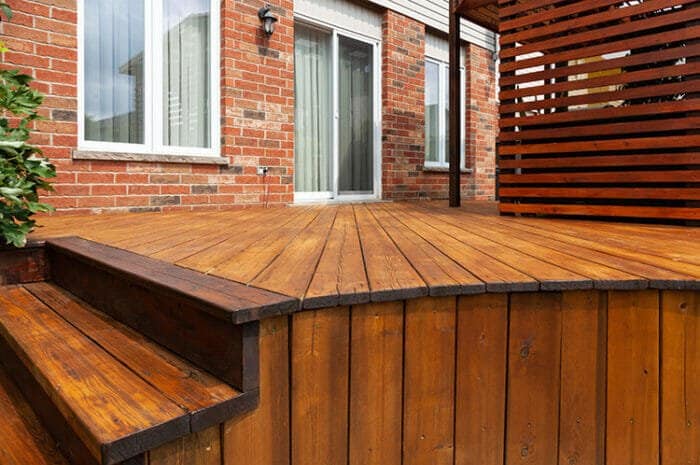 Backyard wooden deck floor boards with fresh brown stain