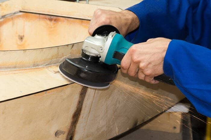 detail of man using rotary sander