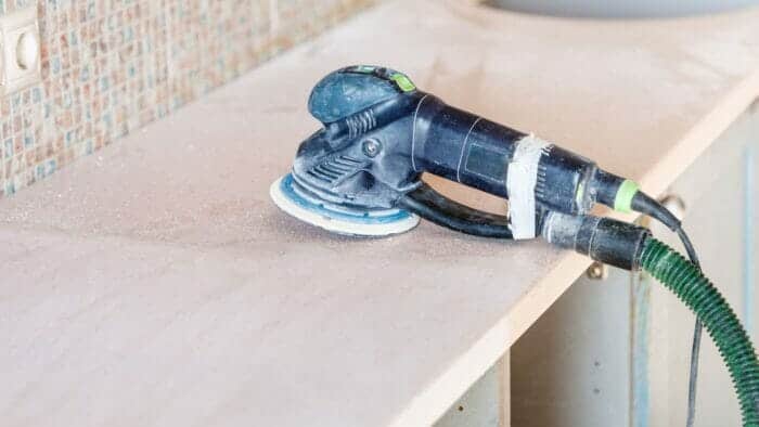 an orbital sander being used to remove water stains from wood