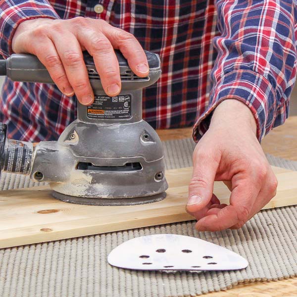 a sanding disc that has been taken off of a random orbital palm sander